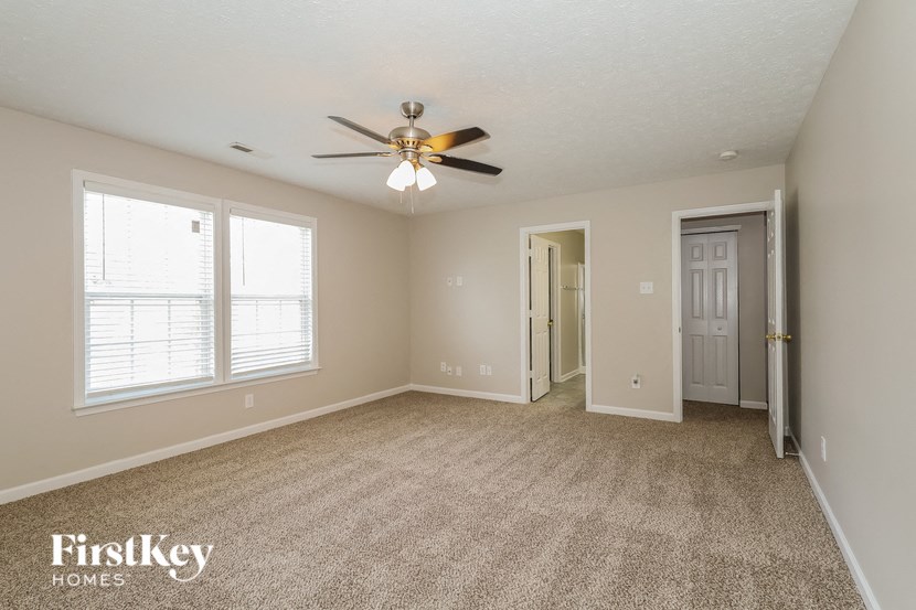 the living room of an empty house with a ceiling fan