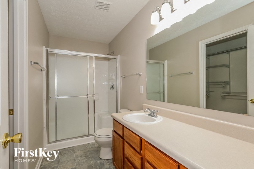 a bathroom with a sink and a shower and a toilet