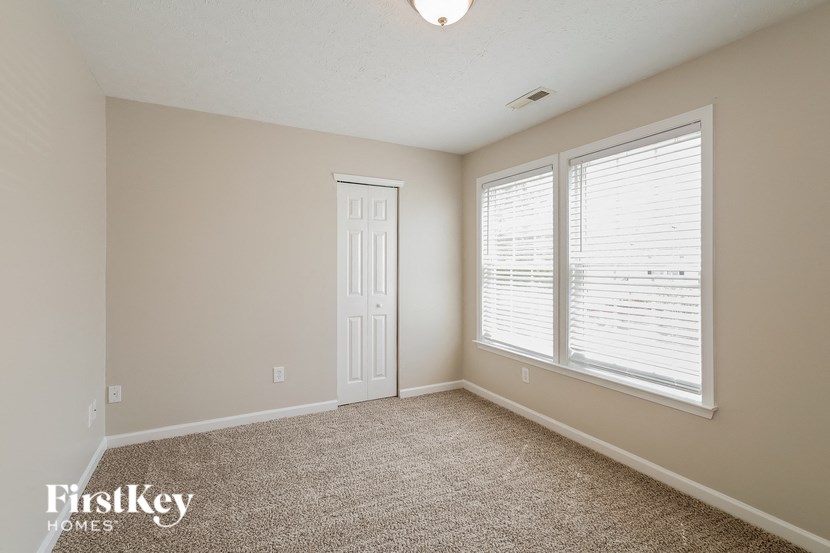 a bedroom with a large window and a white door