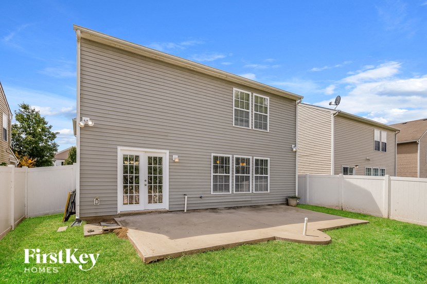 the back of a house with a patio and a yard