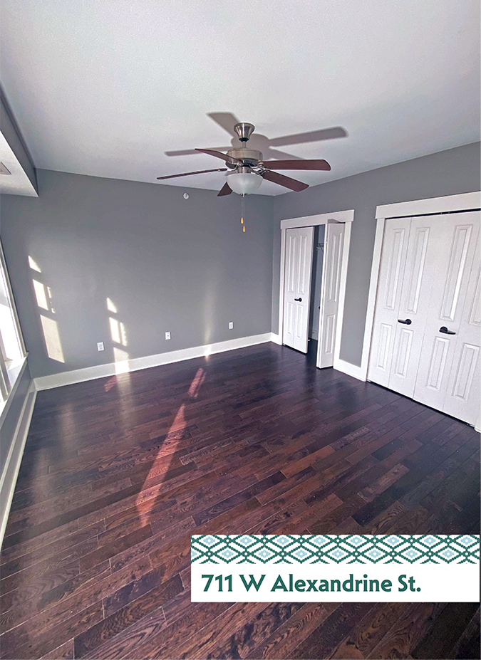 A room with a ceiling fan and wooden flooring.
