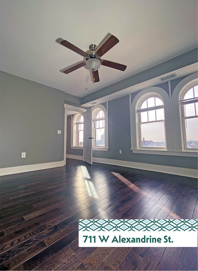 A room with a ceiling fan and wooden floors.