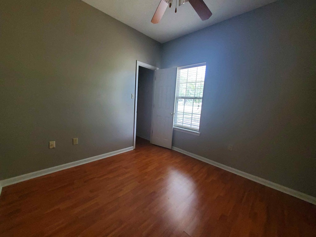 A room with a wooden floor and a ceiling fan.