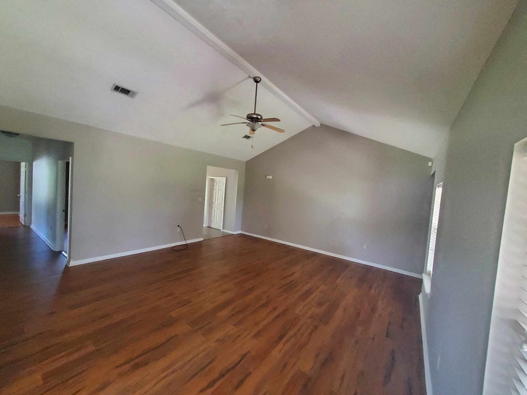 A room with wooden floors and a ceiling fan.