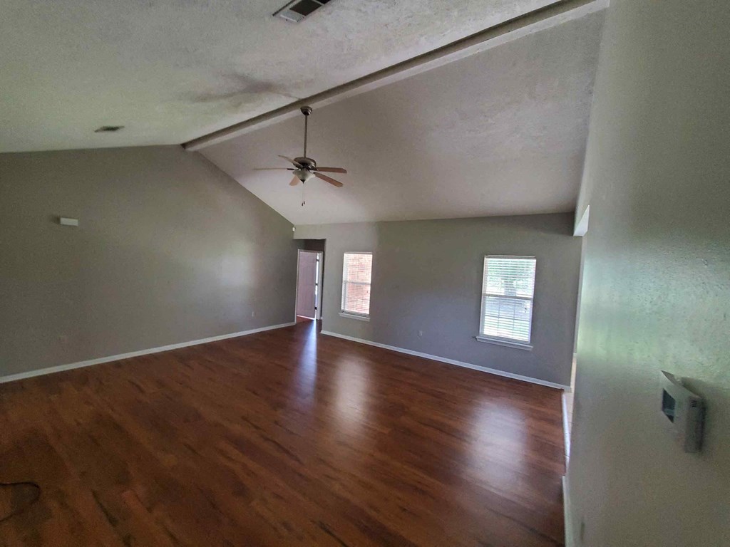 A room with wood floors and a ceiling fan.