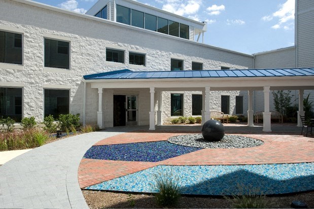 a courtyard in front of a building with a ball in the middle