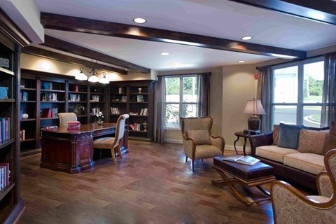 A living room with a bookshelf, a chair, a couch, and a coffee table.