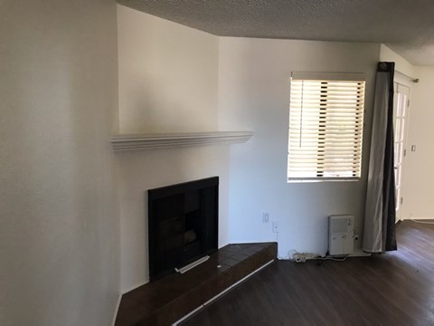 A living room with a fireplace and a television.