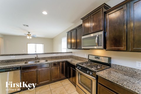 a kitchen with wood cabinets and granite counter tops and stainless steel appliances