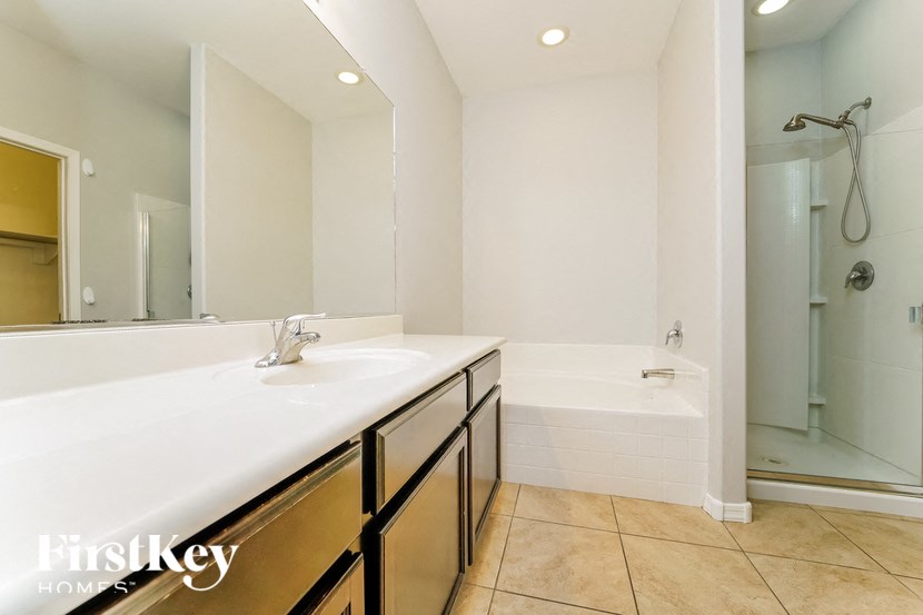 a bathroom with a sink and a tub and a shower