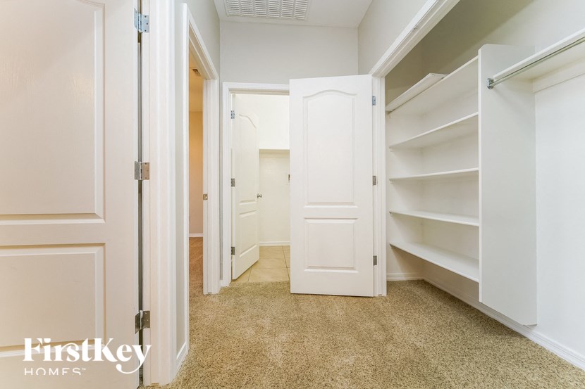 a walk in closet with shelves and a white door