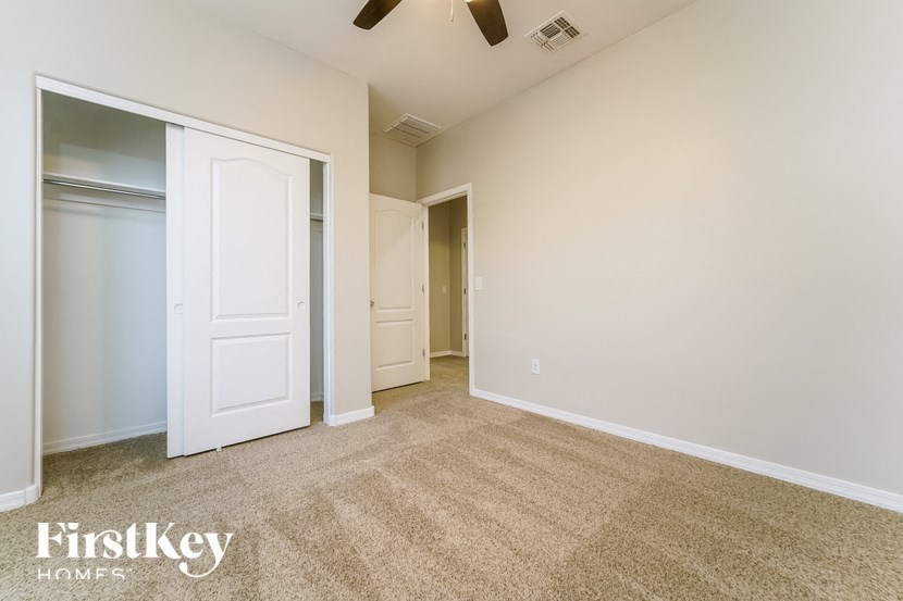 a bedroom with a closet and a door to a hallway