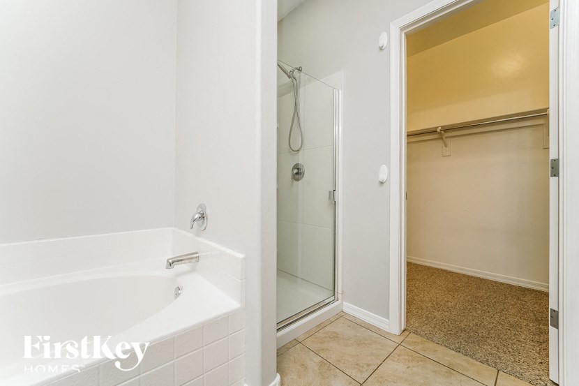 a white bathroom with a tub and a shower