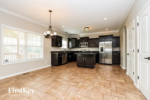 a kitchen with black cabinets and stainless steel appliances and a large window