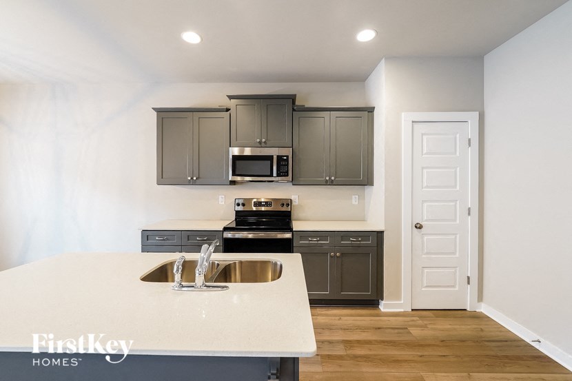 a kitchen with gray cabinets and a white counter top