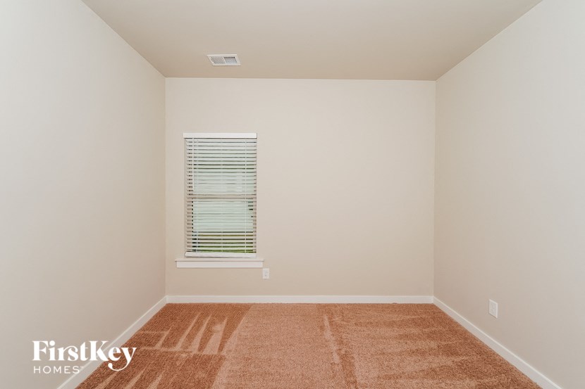 a empty room with a window and a rug