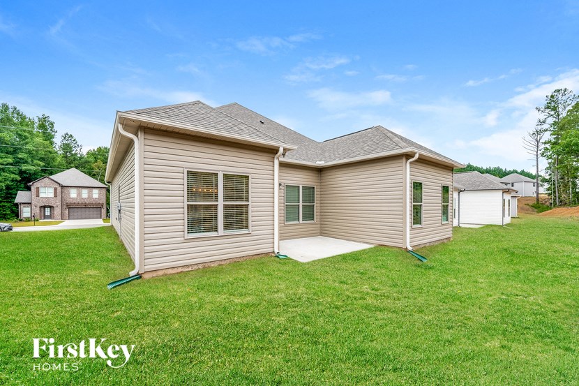 a beige house with a grassy yard and a garage