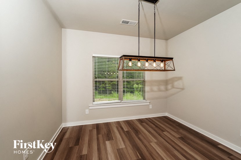 A room with wooden floors and a window with blinds.