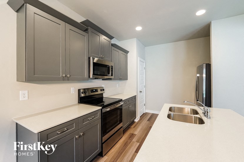 A kitchen with a sink, microwave, and oven.