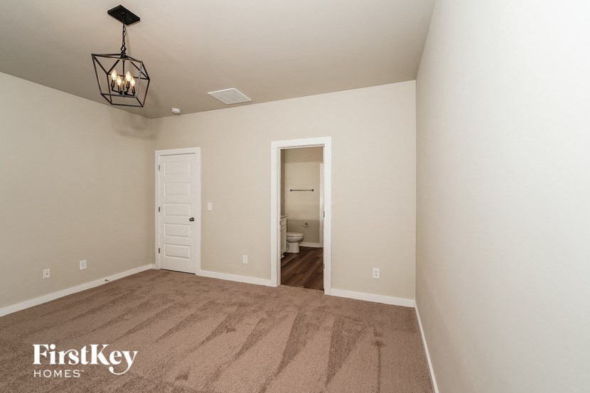 A room with a carpeted floor and a light hanging from the ceiling.