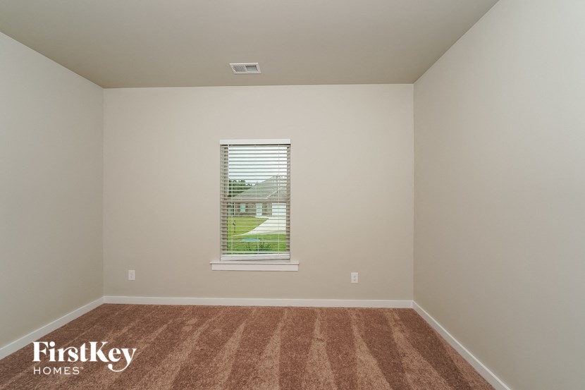 A room with a window and a carpet on the floor.
