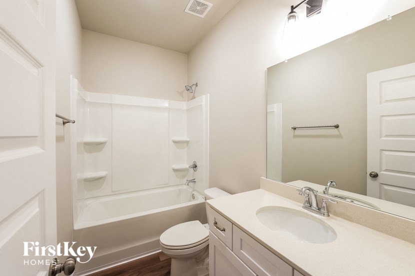 A white bathroom with a toilet, sink, and bathtub.