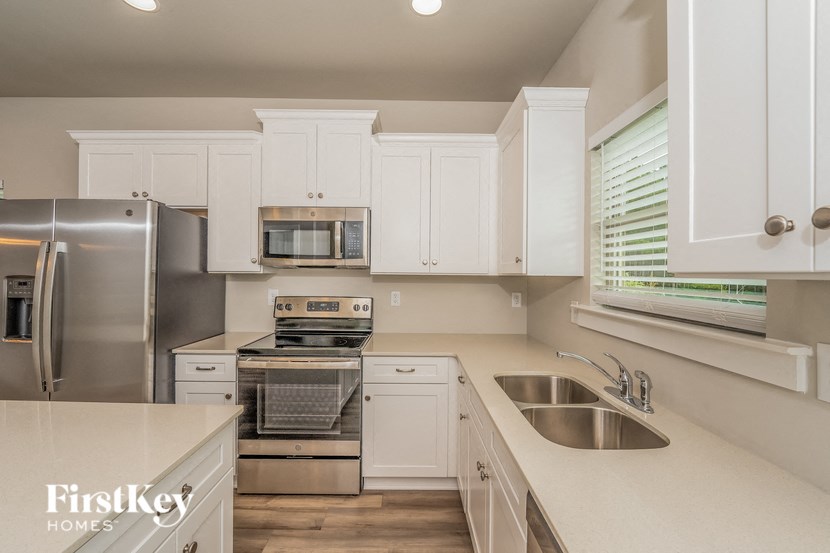 a kitchen with white cabinets and stainless steel appliances
