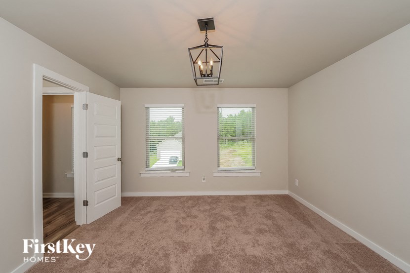 a living room with a carpeted floor and two windows