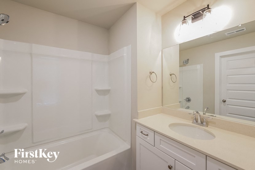 a bathroom with a sink and a bath tub and a mirror