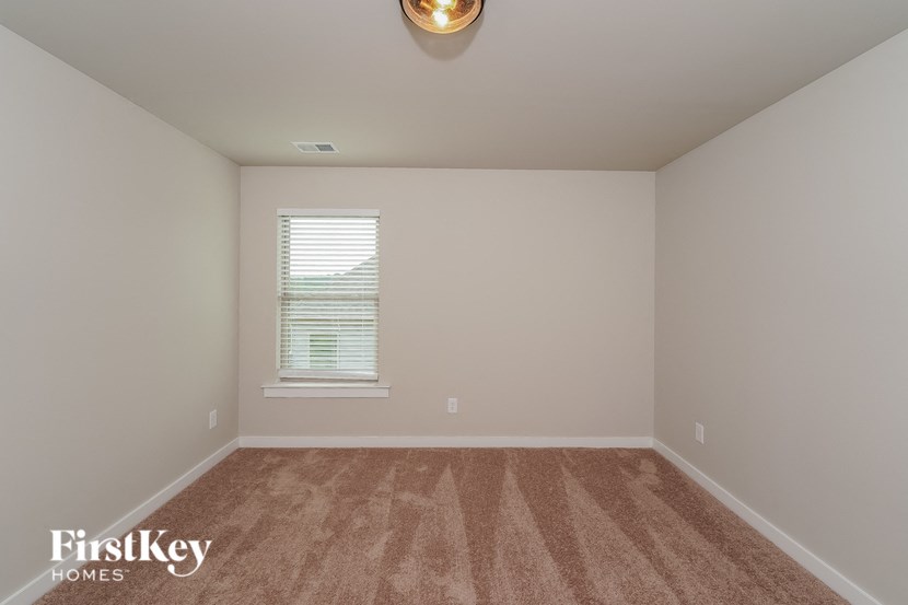 an empty room with carpet and a window