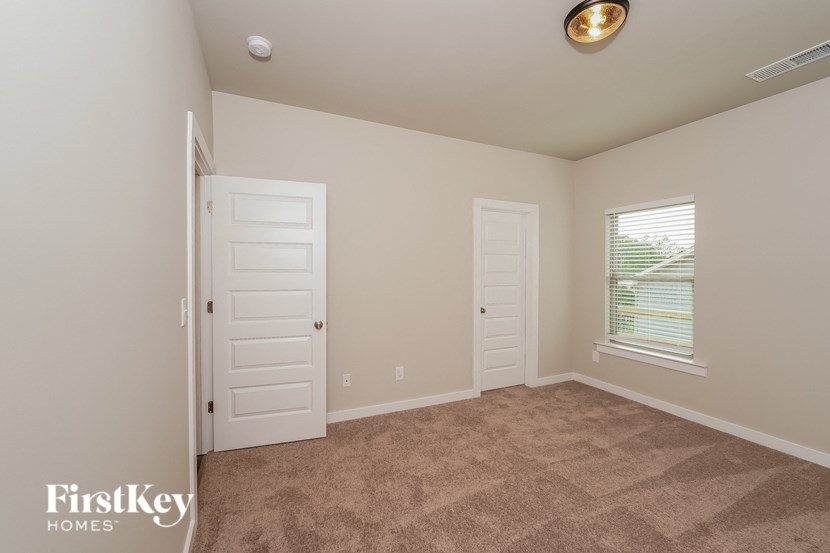 a bedroom with a carpeted floor and two white doors