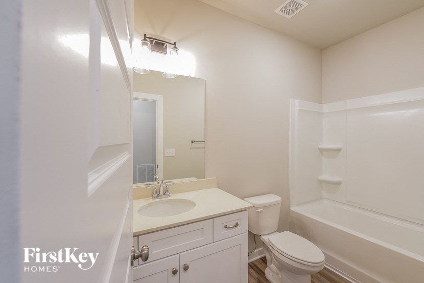 a bathroom with a sink toilet and a mirror
