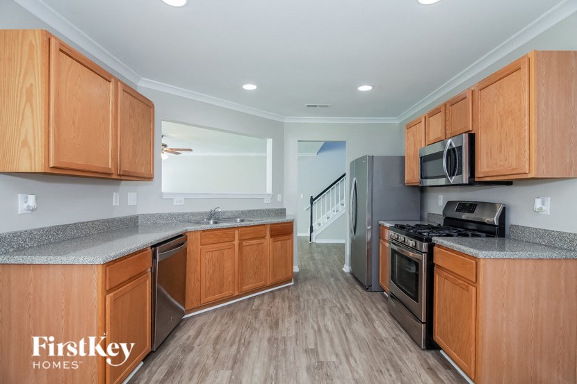 A kitchen with wooden cabinets and a stainless steel refrigerator.
