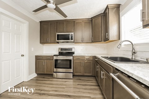 A kitchen with brown cabinets and a stainless steel oven.
