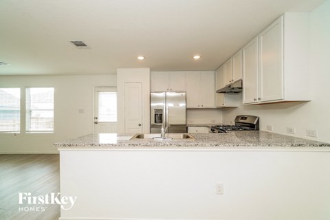 A kitchen with granite countertops and white cabinets.