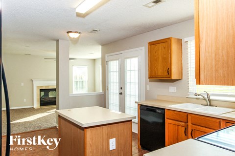 A kitchen with wooden cabinets and a black dishwasher.