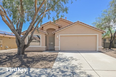 a single story home with a garage and a tree