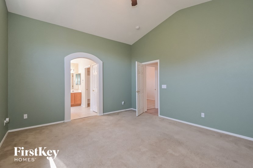 a living room with green walls and a carpet and a door way to a bathroom