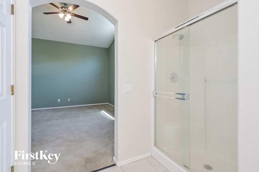 a empty room with a glass closet and a ceiling fan