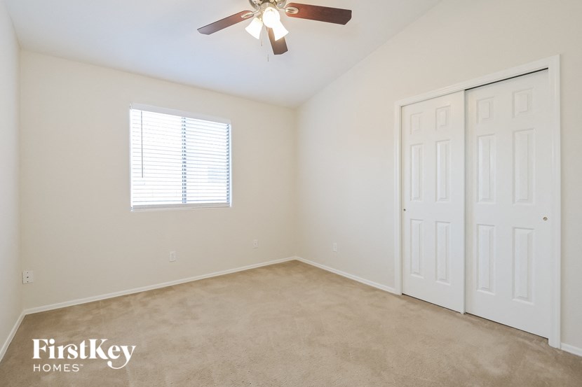 a bedroom with two closets and a ceiling fan