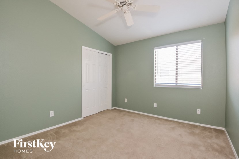 a room with green walls and a white door and a ceiling fan