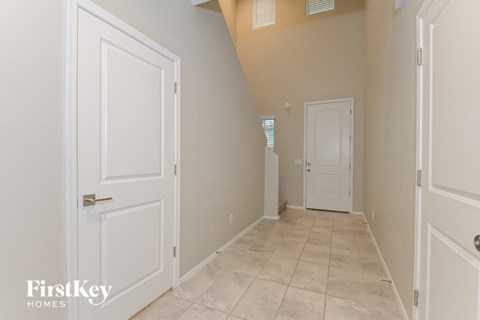 a hallway with white doors and a door to a closet