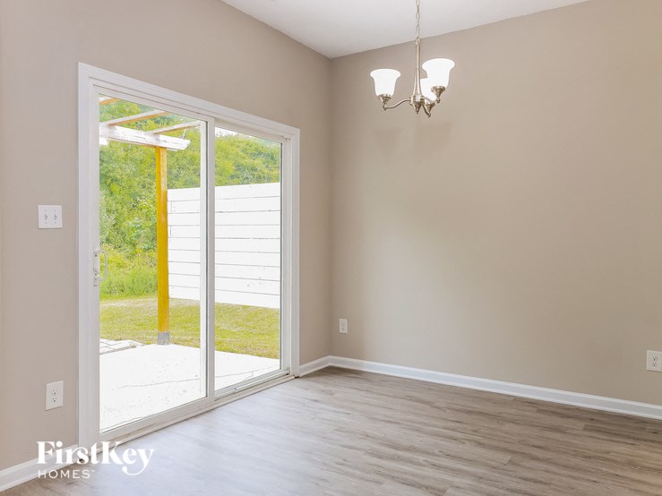 A room with a sliding glass door leading to a backyard.