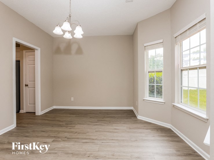 A room with wooden floors and a chandelier hanging from the ceiling.