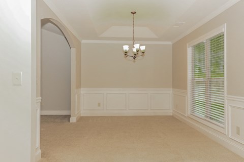a dining room with a large window and a chandelier