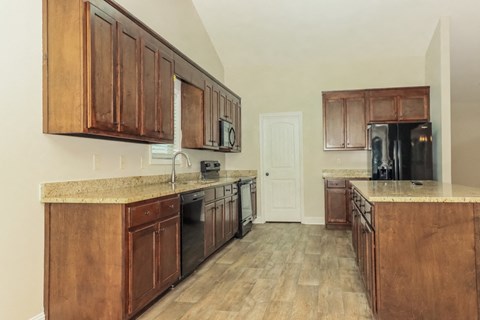 a kitchen with wooden cabinets and appliances and a door