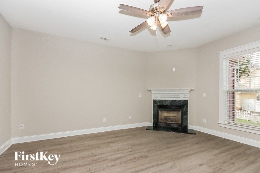 A room with a fireplace and a ceiling fan.