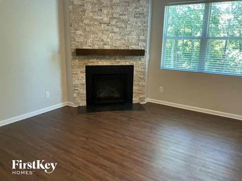 a living room with a hard wood floor and a stone fireplace