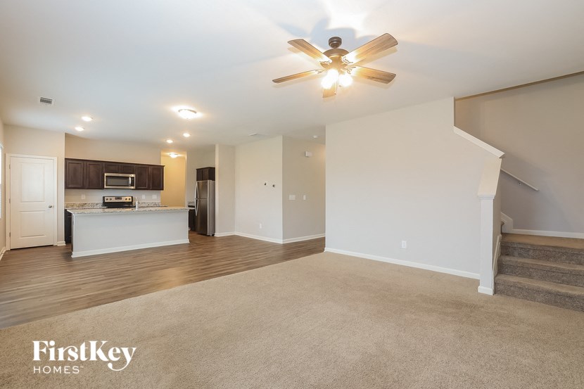 A spacious living room with a staircase leading to the upper floor.