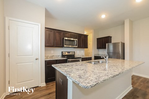 A kitchen with a granite countertop and stainless steel appliances.